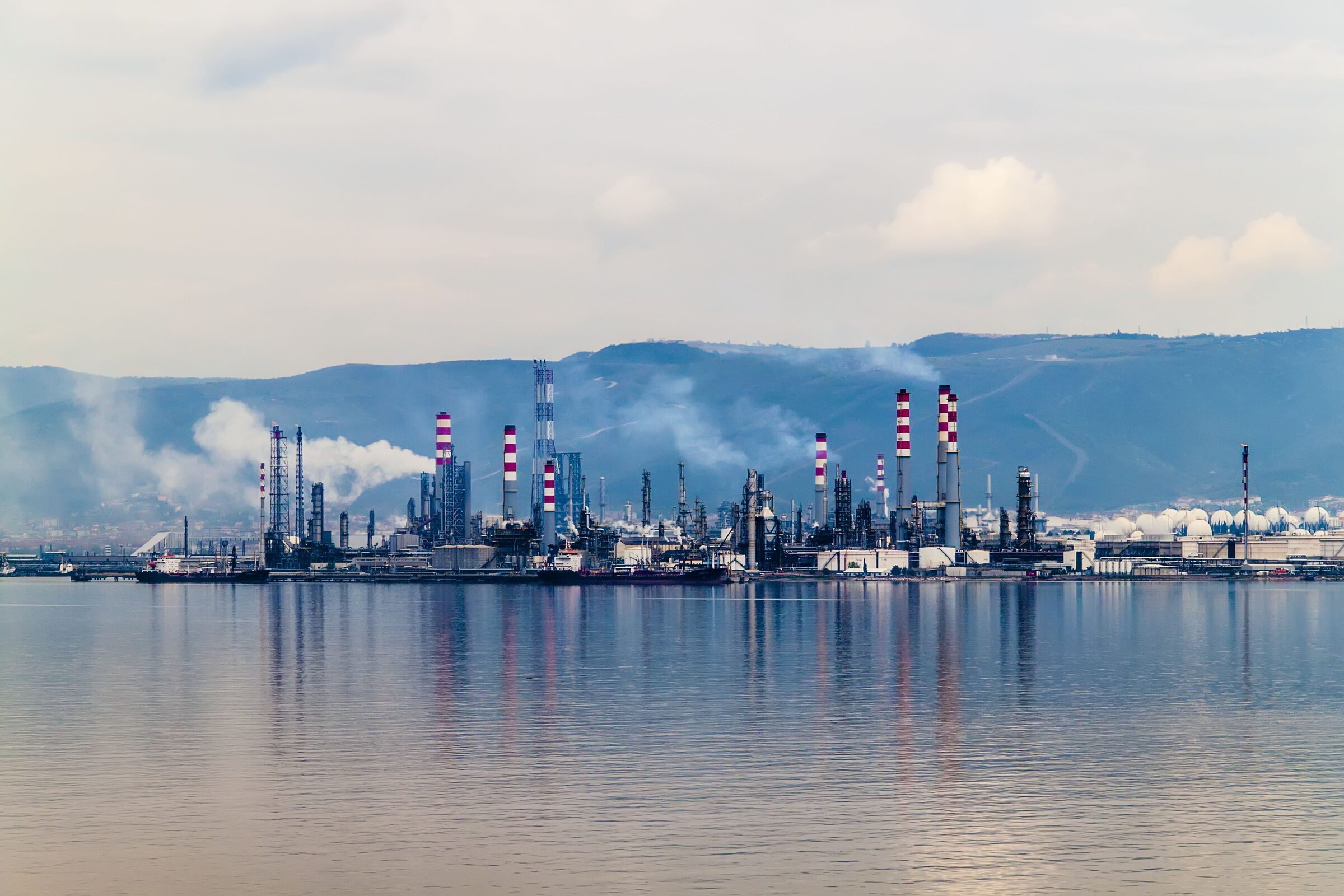 Site de transformation vu depuis l'eau, cheminées et torchères